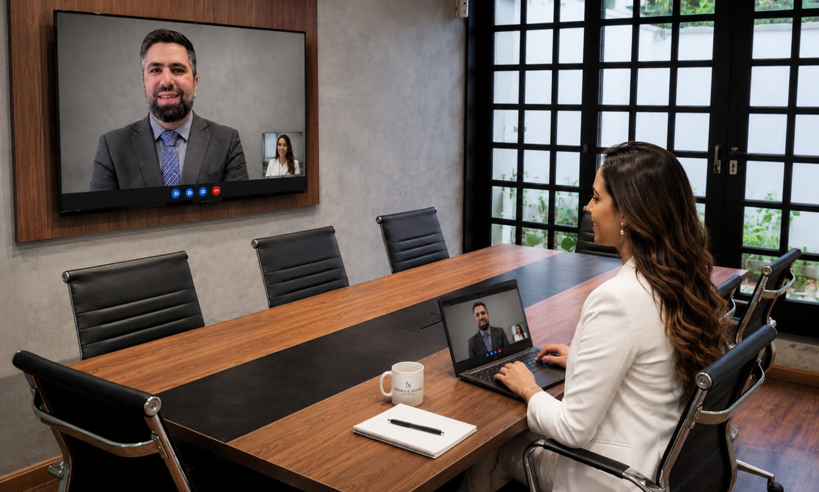 Advogada do escritório Nunes & Nunes em reunião por videochamada, na sala de reuniões